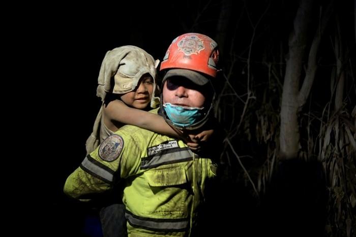 Criança coberta de cinzas é socorrida em El Rodeo, após a erupção de vulcão de Fogo, na Guatemala, no domingo (3) (Crédito: Fabricio Alonzo/ Reuters)