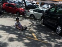 Mãe deixa filho sentado na rua para guardar vaga de estacionamento