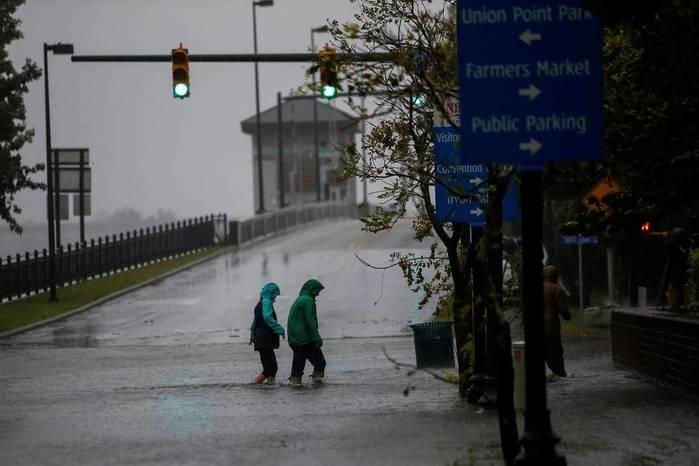 Moradores andam em rua local enquanto as águas do rio Neuse começam a transbordar e alagar casas durante a chegada de Florence à cidade de New Bern, na Carolina do Norte, nesta quinta (Crédito: Eduardo Muñoz/Reuters)