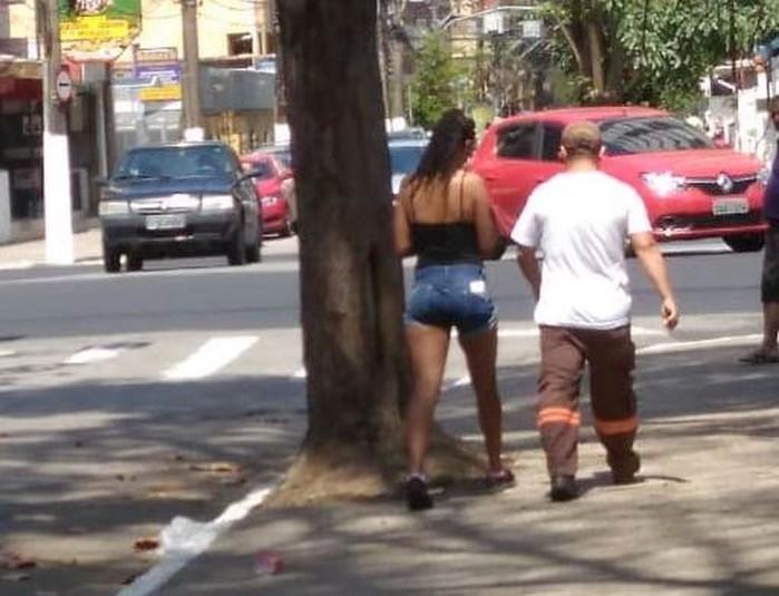 Mulher entra em carro oficial acompanhada de agente de trânsito (Crédito: Reprodução )