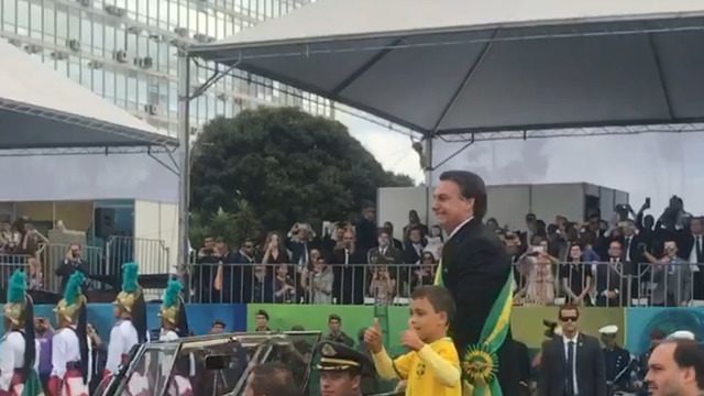 Presidente e o filho repetiram cena da posse e saudaram o público juntos no desfile no Rolls Royce da Presidência. Primeira-dama Michelle Bolsonaro e os filhos Flávio e Eduardo Bolsonaro estão no palanque presidencial