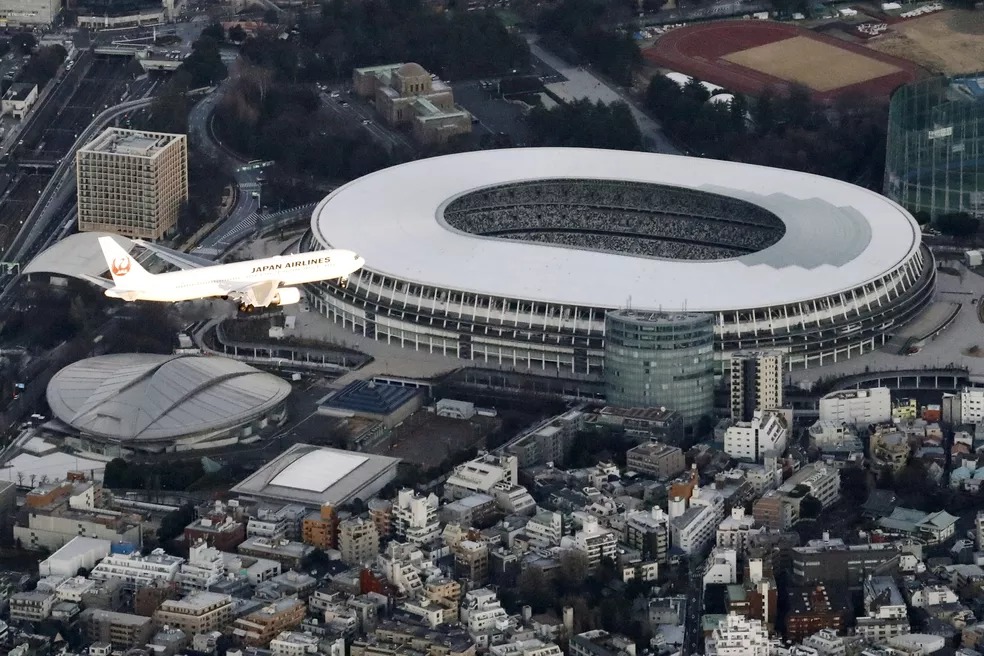 Avião sobrevoa o Estádio Nacional de Tóquio — Foto: Kyodo/via REUTERS Avião sobrevoa o Estádio Nacional de Tóquio — Foto: Kyodo/via REUTERS