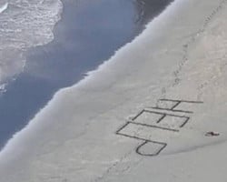 Surfista ferido é resgatado após escrever “Socorro” na areia de praia 