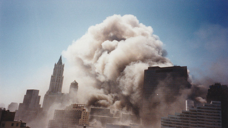 Momento em que as torres foram ao chão, deixando uma cortina de fumaça. (Foto: Liam Enea - Flickr)