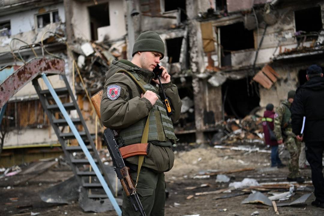 Militar ucraniano em frente a um prédio atingido em um subúrbio da cidade de Kiev, na Ucrânia (Foto: Daniel Leal/AFP) 
