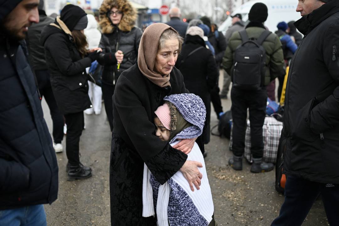 Uma mulher abraça uma menina enquanto refugiados da Ucrânia esperam por transporte na fronteira entre a Moldávia e a Ucrânia, em 1º de março de 2022 (Foto: Nikolay Doychinov/AFP) 