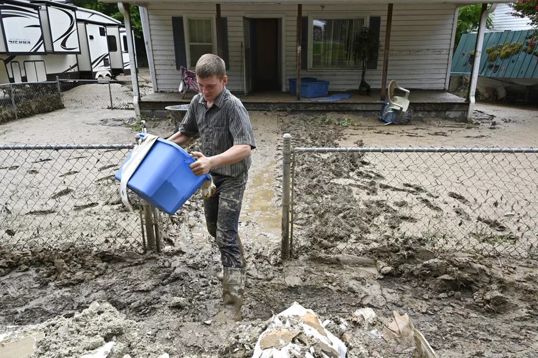 Voluntário ajuda a retirar pertences de casa atingida por inundações em Hindman, no Kentucky, em 31 de domingo 2022. — Foto: Timothy D. Easley/ Associated Press 