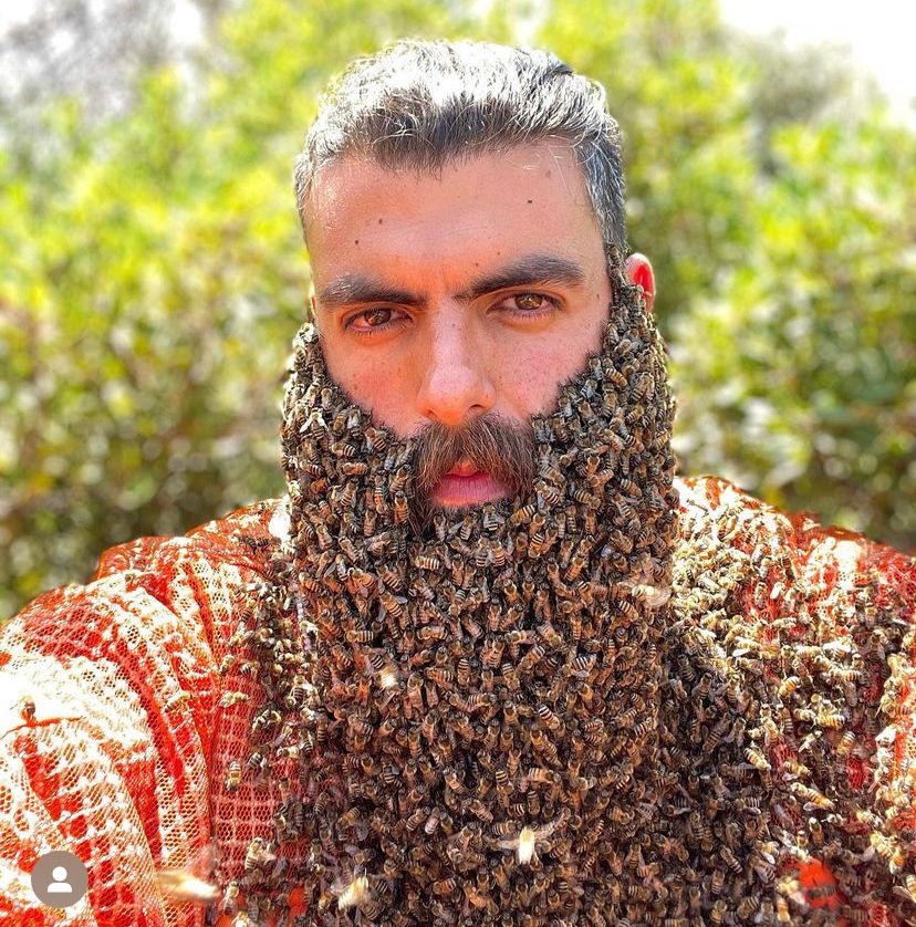 Apicultor aparece com o rosto coberto de abelhas 